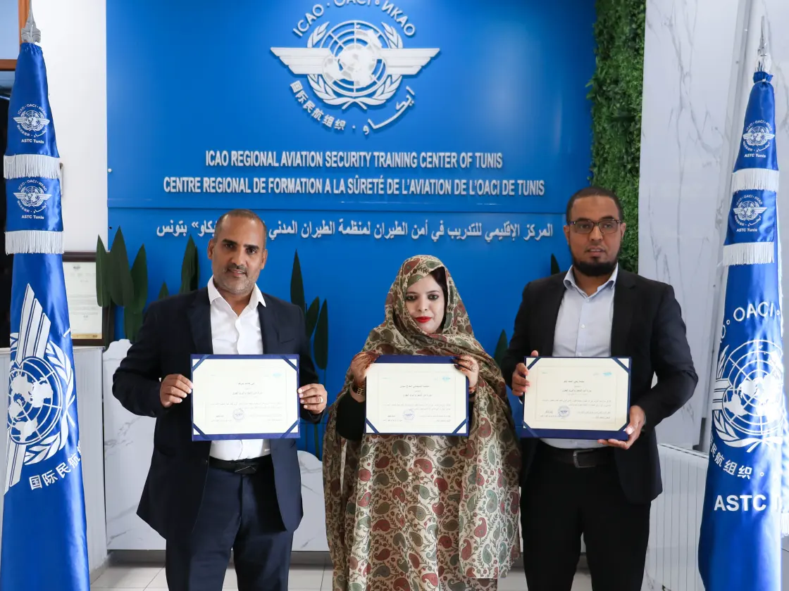 Trois stagiaires présentant leur certificat de formation à la sûreté de l’aviation
